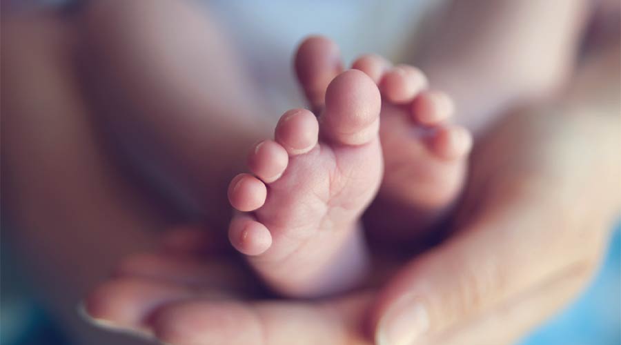 Photo of baby's feet in someone's hands
